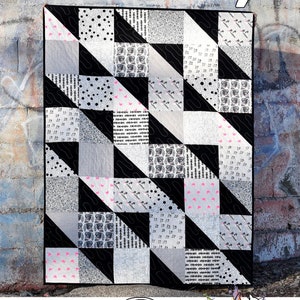 May include: A black and white quilt with a geometric pattern. The quilt is made up of squares and triangles. The quilt is called "Waverly" and is by Running Doe Quilts for Villa Rosa Designs.