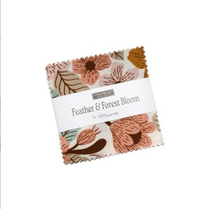 Puede incluir: Una pila de cuadrados de tela con bordes dentados, con un estampado floral en tonos melocotón, marrón y azul claro sobre un fondo crema. Una banda de papel blanco envuelve el centro con el texto Feather & Forest Bloom by Linnwarme.