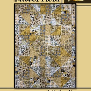 May include: A quilt pattern called "Butterfield" by Villa Rosa Designs. The quilt is made of a variety of fabrics in shades of gold and white. The quilt is quilted in a geometric pattern.