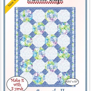 May include: A quilting pattern for a "Snowball" quilt, featuring a floral print fabric in shades of blue, green, and purple. The pattern is designed to create a quilt measuring 43 1/2 inches by 57 inches. The pattern is from Fabric Cafe and requires 3 yards of fabric.