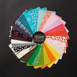Puede incluir: Una disposición circular de muestras de tela variadas con diversos patrones que incluyen peces, flores, cuadros y formas geométricas en un espectro completo de colores. Una etiqueta circular negra central muestra el texto 1-800-CALICO ALEXIA MARCELLE ABEGG.