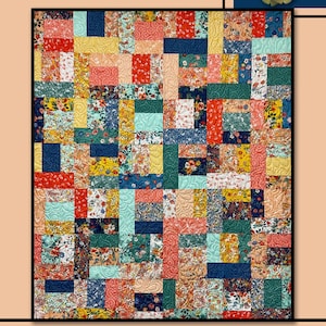 May include: A quilt pattern called "Vienna" by Villa Rosa Designs. The quilt is made up of colorful squares with floral patterns in shades of red, blue, yellow, green, and white. The quilt is surrounded by a border of green leaves and red flowers.