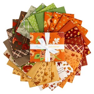 Peut inclure: Un assortiment de carrés de tissu sur le thème de l'automne, aux motifs et couleurs variés, notamment orange, vert, marron et jaune. Les carrés de tissu sont disposés en cercle, avec un paquet central noué d'un ruban blanc. Le texte "create colorfully" est visible.