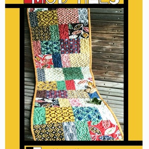 May include: A colorful patchwork quilt runner with a variety of geometric and floral patterns. The runner is made of fabric scraps and has a yellow border. The text "MOD TILES" is at the top of the image. The text "Tricia Lynn Maloney Orphan Quilt Designs For Villa Rosa Designs" is at the bottom of the image.
