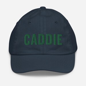 May include: A navy blue baseball cap with the word "CADDIE" embroidered in green.