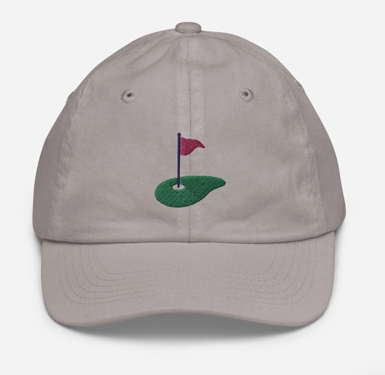 May include: A gray baseball cap with an embroidered green golf course and a red flag.