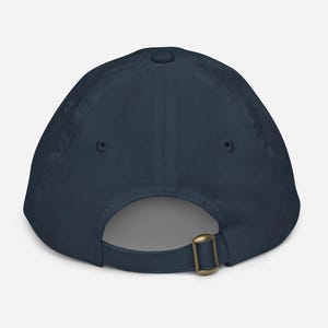 May include: A dark blue baseball cap with an adjustable strap and buckle closure.