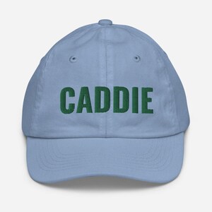 May include: A light blue baseball cap with the word "CADDIE" embroidered in green.
