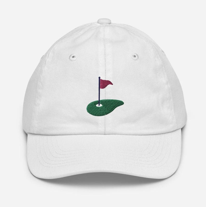 May include: White baseball cap with an embroidered green golf course and a red flag.