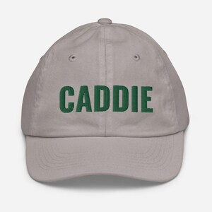 May include: A grey baseball cap with the word "CADDIE" embroidered in green.