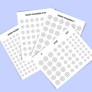 May include: Four sheets of white paper with black daisy flower outlines printed on them. The sheets are labeled "Daisy Flowers 0.75", "Daisy Flowers 1", "Daisy Flow", and "0.5".