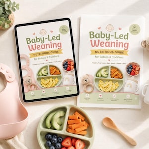 Op de afbeelding: Een digitale tablet en een gedrukte gids getiteld Baby-Led Weaning Nutritious Guide for Babies & Toddlers, inclusief een lichtroze siliconen slabbetje, een saliegroen bord met drie vakken, een houten lepel en een tuitbeker met regenboog.