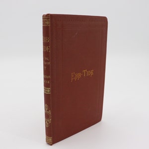 May include: A red hardcover book with gold lettering on the spine and front cover. The title of the book is "Ebb-Tide".