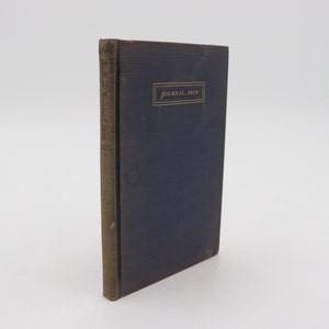 May include: A dark blue hardback book with gold lettering on the spine and front cover. The front cover reads "JOURNAL 1825".