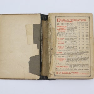 May include: A vintage book with a red and black cover. The cover features the title "Excell's Publications" and a list of publications with prices. The book is open to a page with a price list for various publications, including "Triumphant Songs for Sunday Schools", "The Gospel in Song", "Excell's Anthems", "Easter Service", "Children's Day", and "The Two Ways".