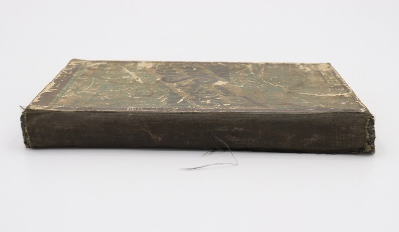 May include: A vintage, brown, rectangular box with a worn, green and white paper cover. The box has a faded, printed design on the top.