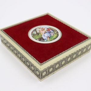May include: A red velvet lined square box with a gold trim and a circular image of Mary and Jesus on the lid.