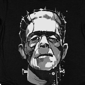 May include: Black t-shirt featuring a graphic print of Frankenstein's monster in a black and white illustration style.