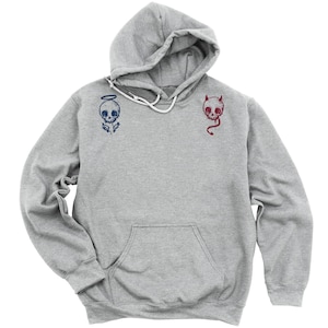 May include: A gray hooded sweatshirt with a skull graphic on each side. The skull on the left has a halo and the skull on the right has horns.