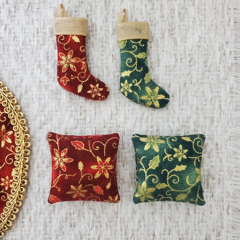 May include: Two small decorative stockings with a red and gold floral pattern and a green and gold floral pattern. Two small square pillows with a red and gold floral pattern and a green and gold floral pattern.