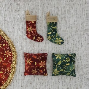 May include: Two small red and green Christmas stockings with gold accents and a floral pattern. Two small square pillows with a similar floral pattern, one red and one green.