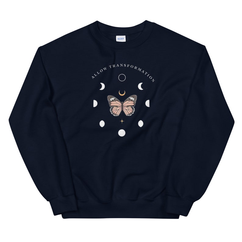 Puede incluir: Sudadera azul marino con un gr&aacute;fico blanco de una mariposa y fases lunares. El texto "ALLOW TRANSFORMATION" est&aacute; escrito en un c&iacute;rculo alrededor de la mariposa.