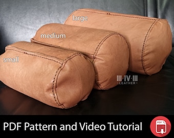 May include: Three brown leather cylindrical pillows of different sizes, labeled "small", "medium", and "large". The pillows are on a black leather surface. The text "III-IV-III -LEATHER- " is visible on the surface.