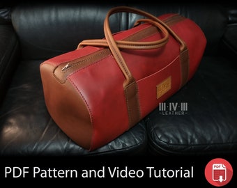 Pode incluir: Uma bolsa de viagem de couro vermelha e marrom com fecho de correr e alça de couro. A bolsa está sentada em um sofá de couro preto. A bolsa tem o texto "III-IV-III -LEATHER- " no lado.