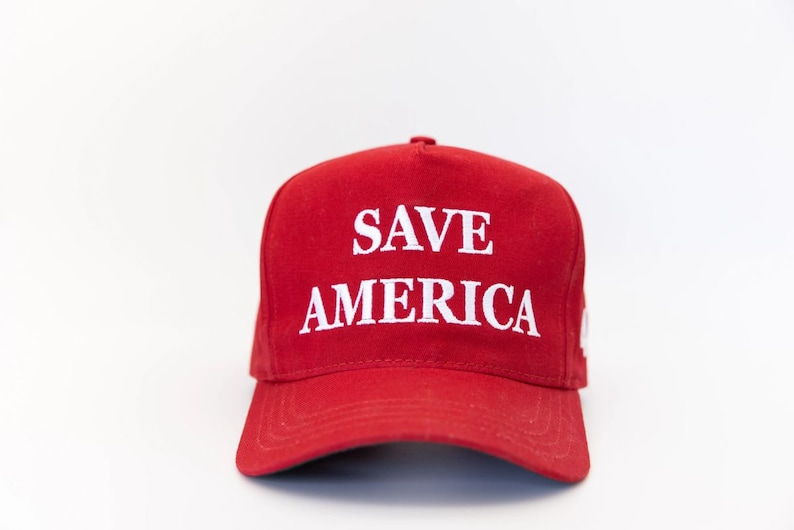 May include: A red baseball cap with a white embroidered slogan that reads "SAVE AMERICA".