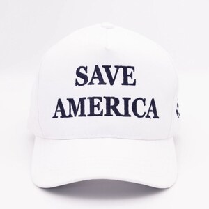 May include: White baseball cap with the text "SAVE AMERICA" embroidered in black.