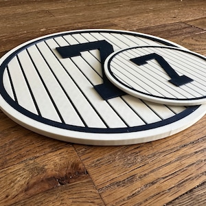 May include: Two white and black circular signs with the number "7" in black on a white background. The signs are made of wood and have a black border.