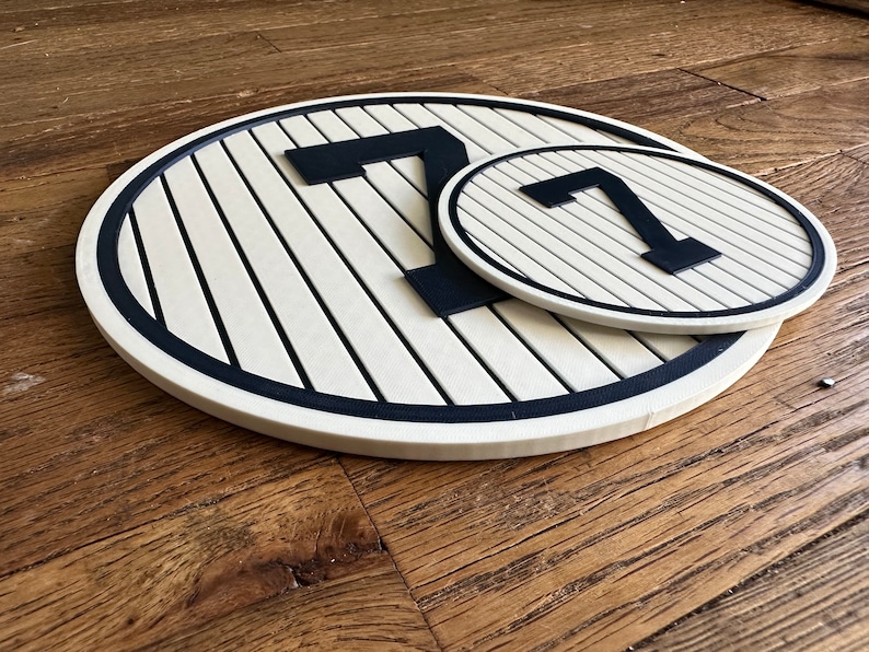 May include: Two white and black circular signs with the number "7" in black on a white background. The signs are made of wood and have a black border.