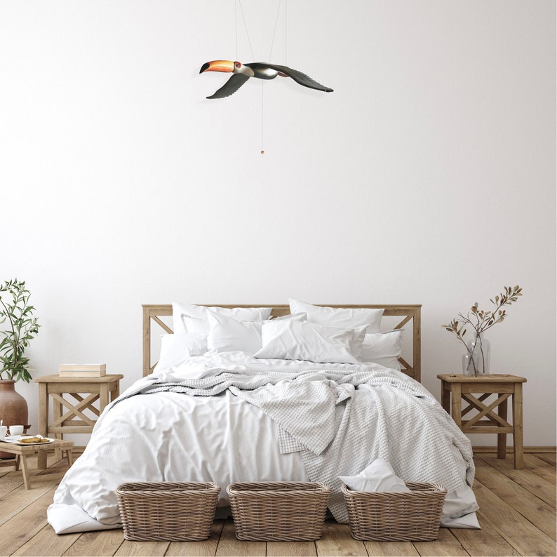 Beautifully carved and painted Toucan Mobile bird in Flight. Shown here above a bed.