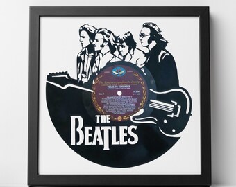 May include: A black vinyl record with a silhouette of The Beatles band members and a guitar. The record label is visible and reads "The London Symphony Society, Years to Remember".