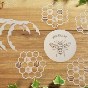 May include: Set of six wooden coasters featuring a honeycomb design with a bee in the center. One coaster has the text "Bee Happy" and a bee illustration.