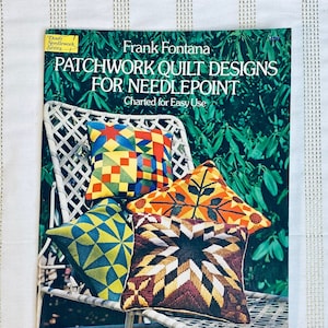 May include: A book titled "Patchwork Quilt Designs for Needlepoint" by Frank Fontana. The book cover features a white wicker chair with three colorful needlepoint pillows. The book is part of the Dover Needlework Series.
