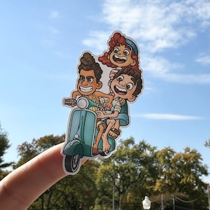 May include: Three cartoon characters riding a blue scooter. The characters are a boy with brown hair, a girl with red hair, and a boy with brown hair. The scooter has a white seat and a white handlebar.