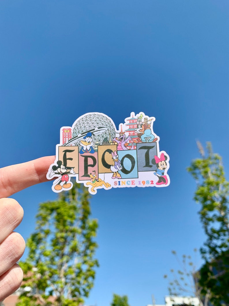 May include: A colorful sticker with the word "EPCOT" in large letters. The sticker features various Disney characters and iconic EPCOT landmarks, including Spaceship Earth and the World Showcase. The text "Since 1982" is printed below the word "EPCOT".