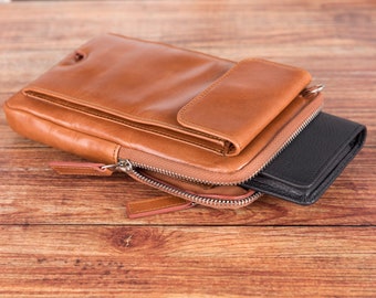 May include: A brown leather zippered pouch with a smaller pocket on the front. The pouch is open and a black leather wallet is inside.