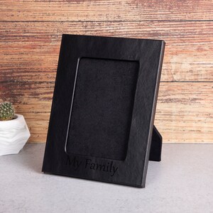 May include: Black wooden picture frame with a stand, featuring the inscription "My Family".