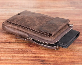 May include: A brown leather wallet with a zippered closure and a flap pocket. The wallet is lying on a wooden surface.