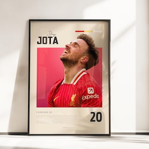 May include: A framed poster featuring a portrait of Diogo Jota in a red Liverpool football jersey against a pink dotted background. The text reads JOTA, FOREVER 20, and includes the number 20, an Expedia logo, and a small LFC crest.