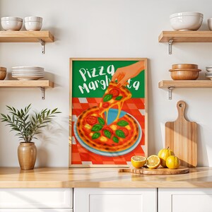 Könnte beinhalten: Ein gerahmter Druck mit einer Pizza Margherita-Illustration. Das Kunstwerk zeigt eine Hand, die eine Pizzascheibe mit geschmolzenem Käse, Tomaten und Basilikum anhebt. Der Hintergrund ist ein rot-weiß kariertes Muster.