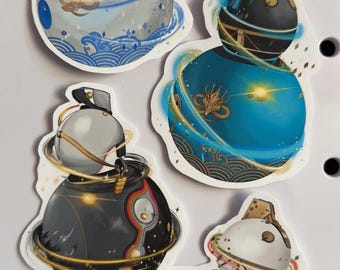 May include: Four stickers featuring celestial-themed designs. Each sticker depicts a spherical object with a planet-like ring, adorned with intricate details and vibrant colors, including blue, gold, and red. The stickers have a glossy finish.