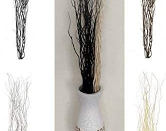May include: Four bunches of artificial willow branches in a white vase. The branches are available in black, white, and beige.