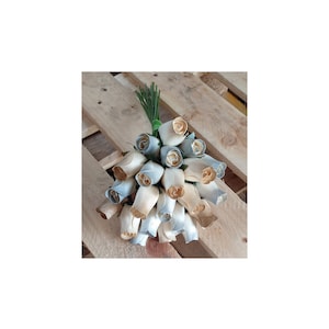 May include: A bouquet of 20 wooden roses in a light blue and cream color scheme. The roses are arranged in a circular shape and are tied together with a green ribbon.