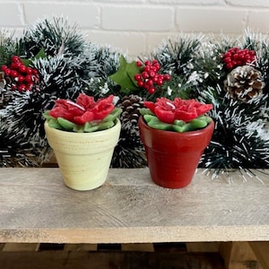 Paire de bougies poinsettia ou décoration de Noël, bougies en forme de fleur avec paillettes dans des pots en céramique, un crème et un rouge