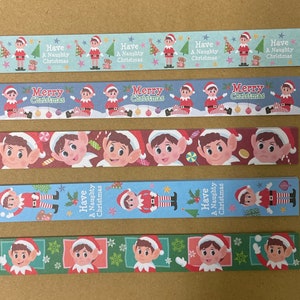 Puede incluir: Cinco tiras diferentes de cinta washi con motivos de duendes navideños. La cinta tiene un fondo azul, verde y rojo con un patrón repetitivo de duendes. El texto en la cinta dice "Have a Naughty Christmas" y "Merry Christmas".