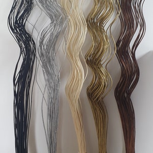 May include: Five bundles of wavy, flexible stems in different colors: black, silver, cream, gold, and brown. The stems are tied together at the bottom.