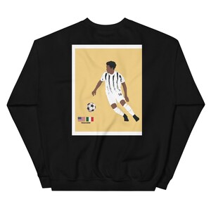 May include: Black sweatshirt with a graphic print of a soccer player in a black and white jersey kicking a soccer ball. The graphic also includes the text "Texas Born" and the flags of the United States and Italy.